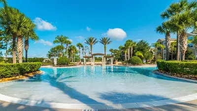 a swimming pool with palm trees in a resort at AF2574 - Windsor Hills Resort Vacation Home in Orlando