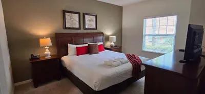 a bedroom with a bed with red pillows and a desk at 3BR Townhome West Lucaya Resort Close to Disney in Kissimmee