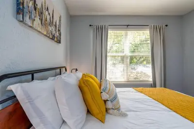 a bedroom with a bed with yellow and white pillows at Large 3 bedroom with King Bed in Orlando