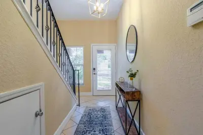 a hallway of a home with a staircase and a mirror at Large 3 bedroom with King Bed in Orlando
