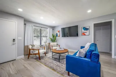 a living room with a blue couch and a table at Large 2 bedroom with King bed and Patio in Orlando