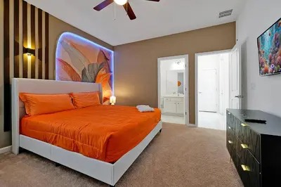 a bedroom with an orange bed and a dresser at Luxury and Sophisticated 15 BR ensuite in Kissimmee
