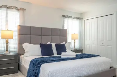 a bedroom with a large bed with blue and white pillows at Beautiful 4 BR close to Disney in Kissimmee