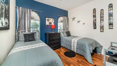 two beds in a bedroom with blue walls at FP8157 - Windsor Palms Resort 4 Bedroom Home With Game Room in Kissimmee