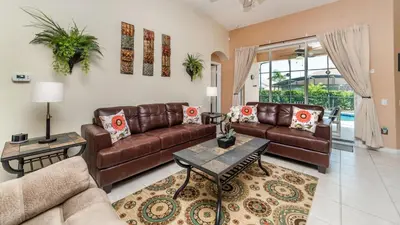 a living room with couches and a table at FP8157 - Windsor Palms Resort 4 Bedroom Home With Game Room in Kissimmee