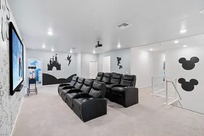 a waiting room with black leather chairs and a screen at Upstay 15BR Villa w Games Room, Pool & Cinema in Kissimmee