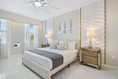 a bedroom with a large bed and a ceiling fan at Upstay 15BR Villa w Games Room, Pool & Cinema in Kissimmee