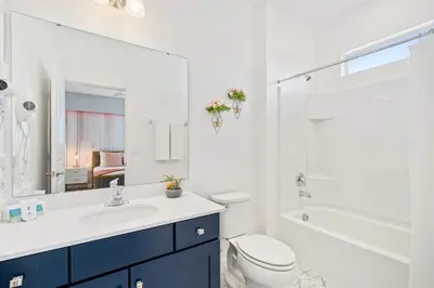 a white bathroom with a sink and a toilet at Upstay 15BR Villa w Games Room, Pool & Cinema in Kissimmee