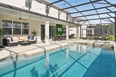 a swimming pool with a patio and a house at Upstay 15BR Villa w Games Room, Pool & Cinema in Kissimmee