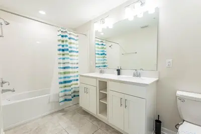 a bathroom with a sink and a tub and a toilet at Comfortable 2BR Condo w Lake Views in Kissimmee