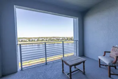 a room with a large window with a chair and a table at Comfortable 2BR Condo w Lake Views in Kissimmee