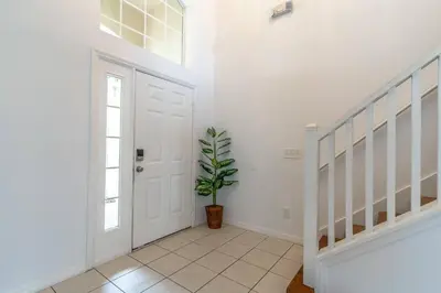 a hallway with a white door and a potted plant at 8512 Emerald Island in Kissimmee