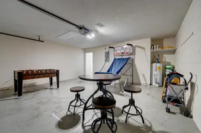a room with a ping pong table and stools in it at Sun Kissed Pool Home in Kissimmee in Kissimmee