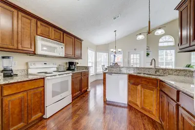 a kitchen with white appliances and wooden cabinets at Sun Kissed Pool Home in Kissimmee in Kissimmee