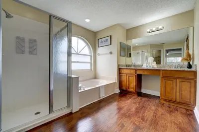 a bathroom with a shower and a tub and a sink at Sun Kissed Pool Home in Kissimmee in Kissimmee