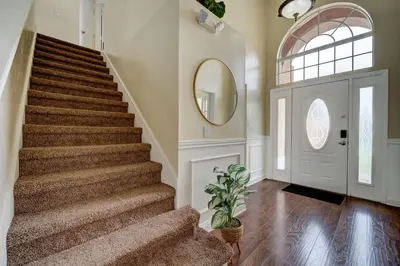 a staircase in a home with a round mirror and a door at Sun Kissed Pool Home in Kissimmee in Kissimmee