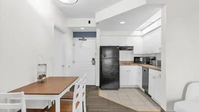 a kitchen with a table and a black refrigerator at Condo with Hot Tub and Pool in Orlando