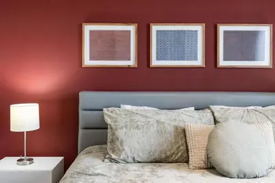 a bedroom with red walls and a bed with a lamp at Amzing location 3BDR House - 8980 in Kissimmee