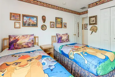 two beds in a room with pictures on the wall at 3 Mi to Disney World Poolside Oasis with Game Room in Kissimmee