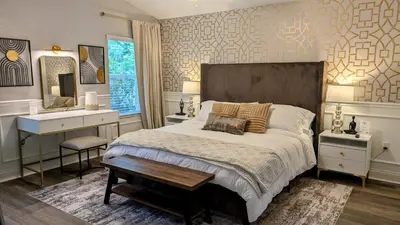 a bedroom with a large bed with a desk and a table at Modern 3BR Home 10 Min from MCO in Orlando