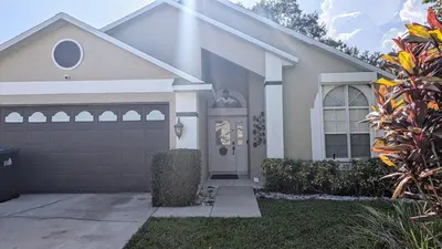 a house with a driveway and a garage at Modern 3BR Home 10 Min from MCO in Orlando