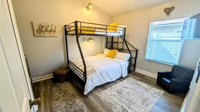 a bedroom with a bunk bed and a chair at Modern 3BR Home 10 Min from MCO in Orlando