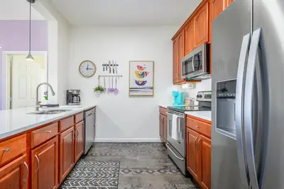 a kitchen with wooden cabinets and a stainless steel refrigerator at 4862 Cayview Avenue 208 in Orlando