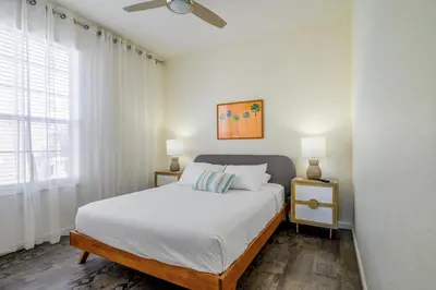a bedroom with a bed with white sheets and a ceiling fan at 4862 Cayview Avenue 208 in Orlando