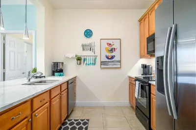 a kitchen with wooden cabinets and a stainless steel refrigerator at 4862 Cayview Avenue 408 in Orlando