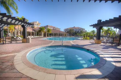 a swimming pool in a resort with tables and chairs at 4862 Cayview Avenue 408 in Orlando