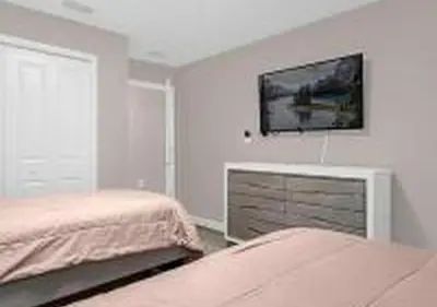 a bedroom with two beds and a tv on the wall at 4243 PA - Storey Lake Escape 4BR Pool Home Near Disney in Kissimmee