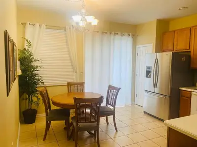 a kitchen with a table and chairs and a refrigerator at Paraíso Magico Getaway 5152 in Kissimmee