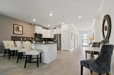 a kitchen with white cabinets and a table and chairs at 2900SS SL Family Lakeview Escape Disney-Themed Fun 8 Mins to Parks in Kissimmee