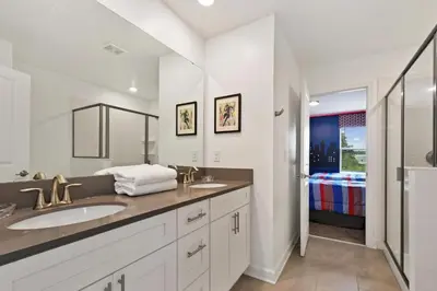 a bathroom with two sinks and a large mirror at 2900SS SL Family Lakeview Escape Disney-Themed Fun 8 Mins to Parks in Kissimmee