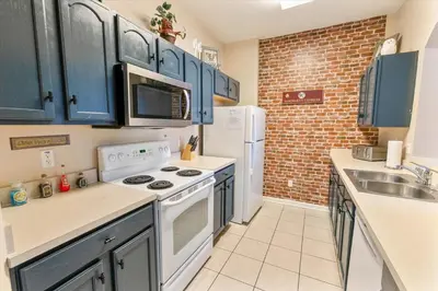 a kitchen with blue cabinets and white appliances at 2784 Almaton 404 in Orlando