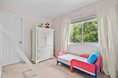 a bedroom with a red chair and a window at Large house at Windsor Hills Resort in Orlando