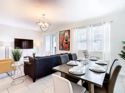 a living room with a table and a couch at Amazing 5BR Townhouse near Disney - Private Pool in Kissimmee
