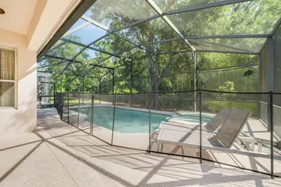 a glass house with a swimming pool and a patio at The Hearth Home - 4 Suites in Kissimmee