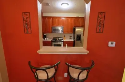 a kitchen with red walls and two black chairs at 2 Bedroom private lakeview by Conference Center and Epic Universe walking distance in Orlando