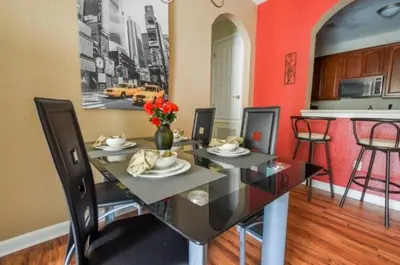 a dining room with a table with a vase of flowers at 2 Bedroom private lakeview by Conference Center and Epic Universe walking distance in Orlando