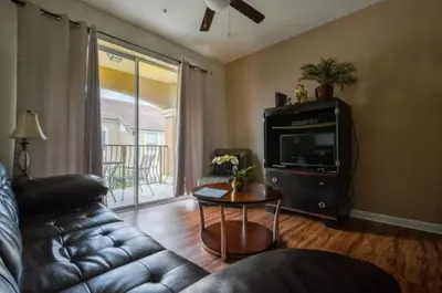 a living room with a leather couch and a table at 2 Bedroom private lakeview by Conference Center and Epic Universe walking distance in Orlando