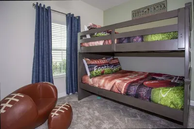 a bedroom with a bunk bed with a football at 5BR Private Pool Resort Amenities Near Disney in Kissimmee