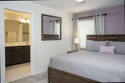 a bedroom with a bed and a mirror and a sink at 5BR Private Pool Resort Amenities Near Disney in Kissimmee