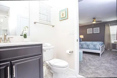 a bathroom with a toilet and a sink and a bed at 5BR Private Pool Resort Amenities Near Disney in Kissimmee