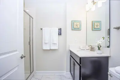 a white bathroom with a sink and a mirror at 5BR Private Pool Resort Amenities Near Disney in Kissimmee