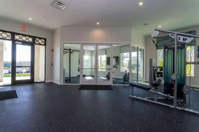 a gym with treadmills and machines in a room at 5BR Private Pool Resort Amenities Near Disney in Kissimmee