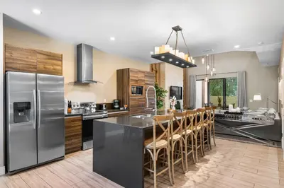 a kitchen with stainless steel appliances and wooden cabinets at Magic Getaway 4 En-suites, BBQ & Near Parks in Orlando
