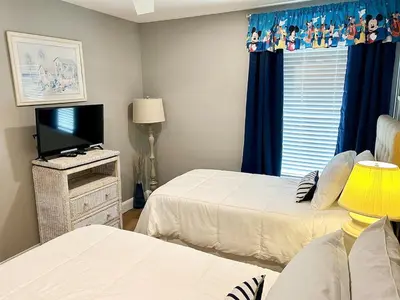 a bedroom with two beds and a flat screen tv at The Palms 1st floor By Pool, Fully Stocked 5 stars in Kissimmee