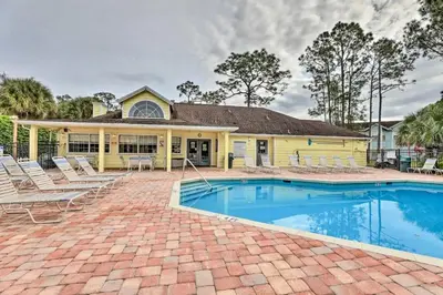 a yellow house with a swimming pool and chairs at The Palms 1st floor By Pool, Fully Stocked 5 stars in Kissimmee