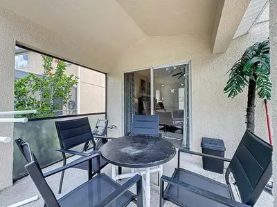 a patio with a table and chairs and a palm tree at Terra Verde Resort 4 Bed Pool Spa Villa villa in Kissimmee